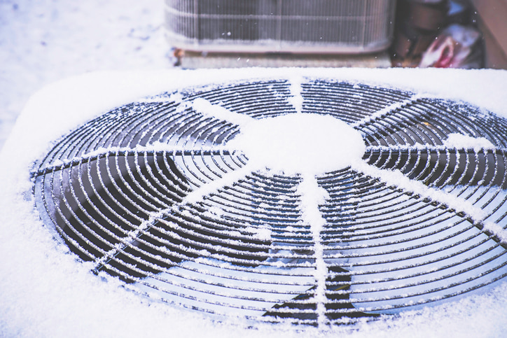 HVAC unit outdoors covered in snow